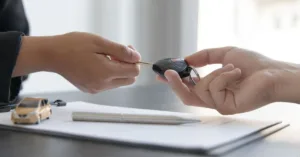 Entrega de chave de carro durante assinatura de contrato de compra e venda de veículo usado.