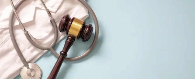 Martelo da justiça ao lado de estetoscópio simbolizando erro médico e responsabilidade jurídica