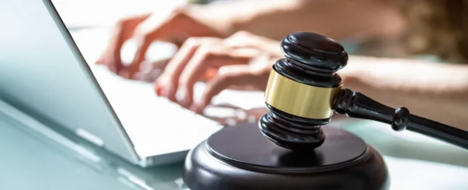 Responsabilidade civil por danos morais na internet representada por um martelo da justiça ao lado de um notebook.