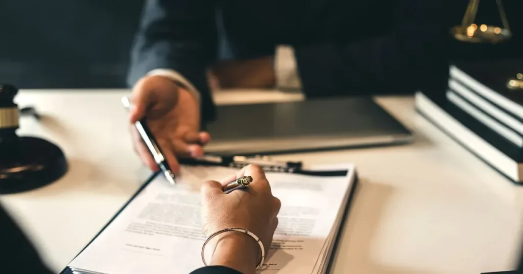 Pessoa assinando contrato sob orientação jurídica — direito civil e inadimplência contratual