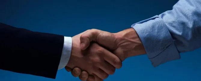 Aperto de mãos simbolizando um contrato verbal entre duas pessoas.