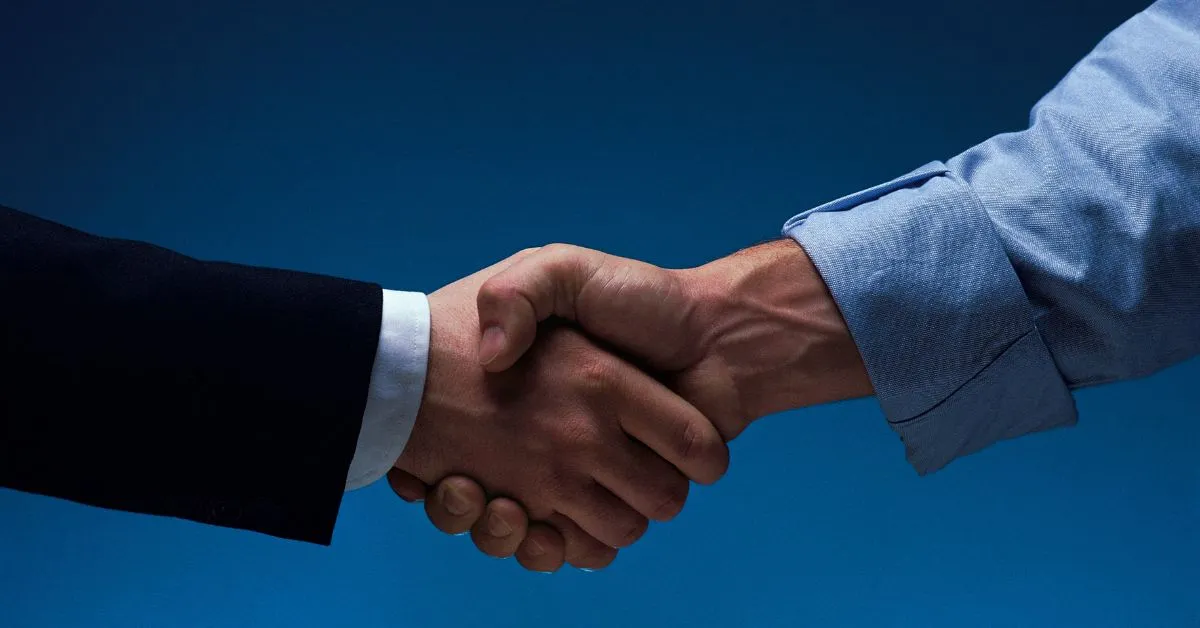 Aperto de mãos simbolizando um contrato verbal entre duas pessoas.