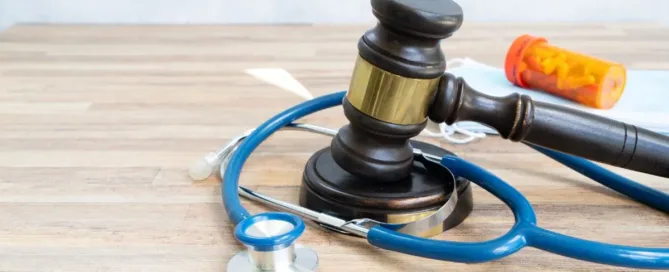 Martelo da justiça com estetoscópio e frasco de remédio simbolizando negativa de plano de saúde