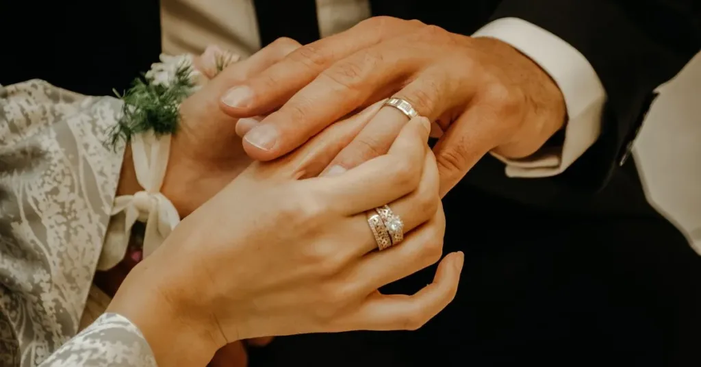 Mãos de casal com alianças simbolizando casamento e regime de bens