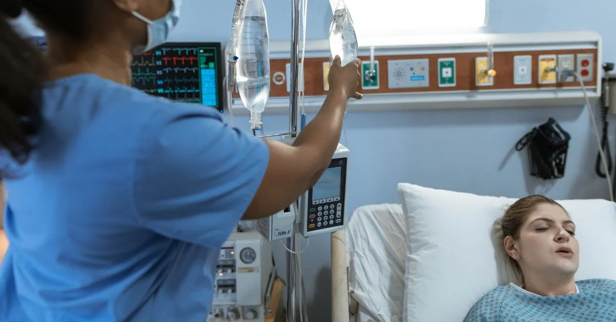 Profissional da saúde ajustando soro em paciente internada em hospital