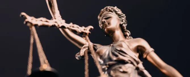 Estátua da justiça segurando balança, simbolizando o direito à indenização por dano moral