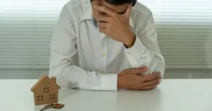 Pessoa entregando uma casa simbolizando penhora de imóvel por dívidas.