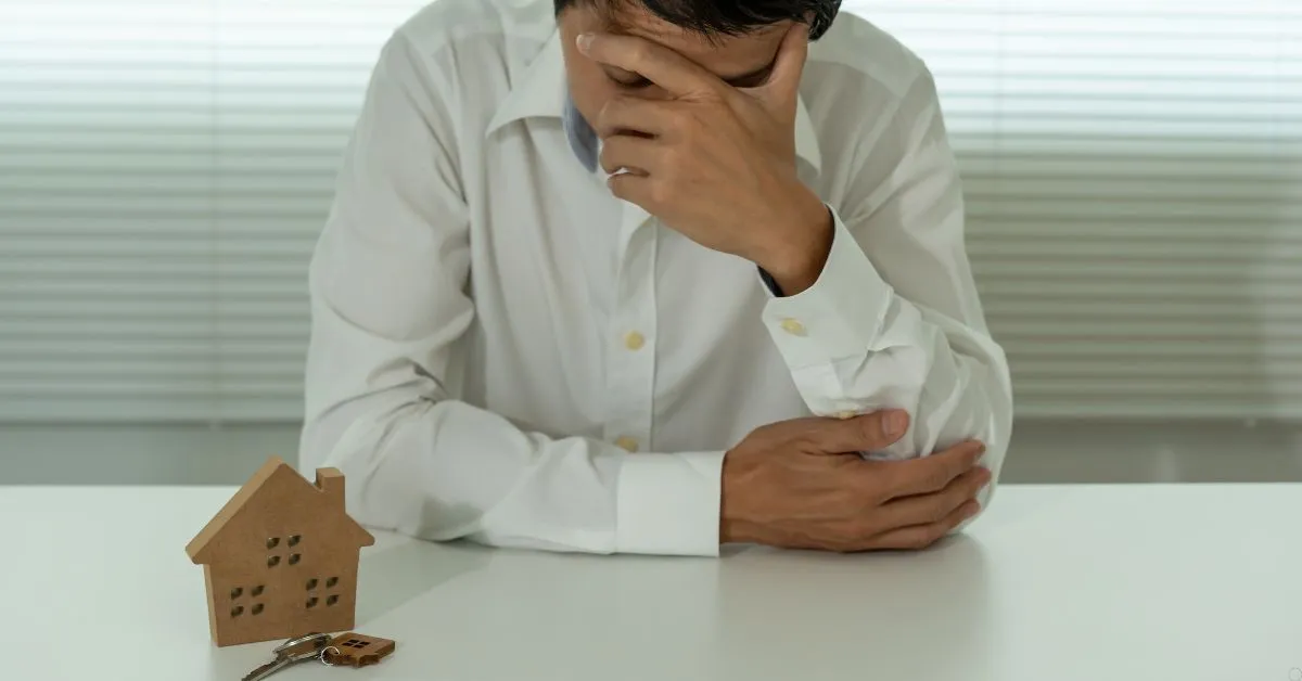 Pessoa entregando uma casa simbolizando penhora de imóvel por dívidas.