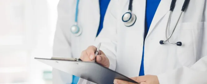 Médicos com estetoscópio analisando prontuário em prancheta hospitalar