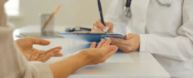 Paciente conversa com médico durante consulta para revisar alta médica precoce.