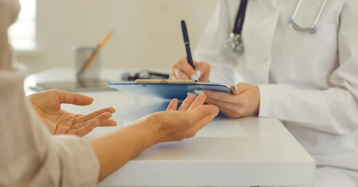 Paciente conversa com médico durante consulta para revisar alta médica precoce.