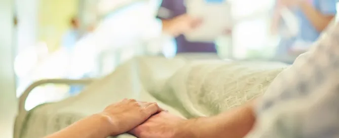 Paciente em hospital público segurando a mão de familiar após erro médico