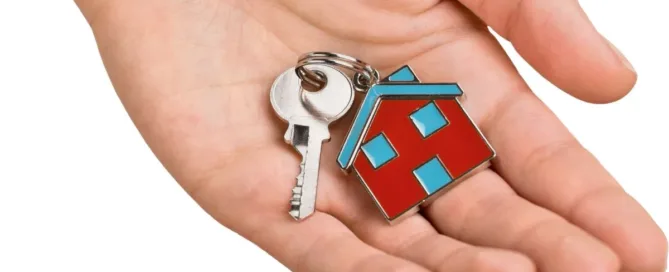 Imagem de uma mão segurando uma chave com chaveiro em formato de casa, representando o conceito jurídico de posse e propriedade no contexto de compra e venda de imóveis.