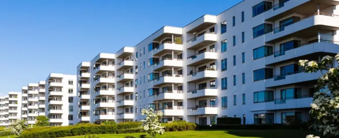 Fachada de condomínio residencial com jardins bem cuidados e sacadas modernas