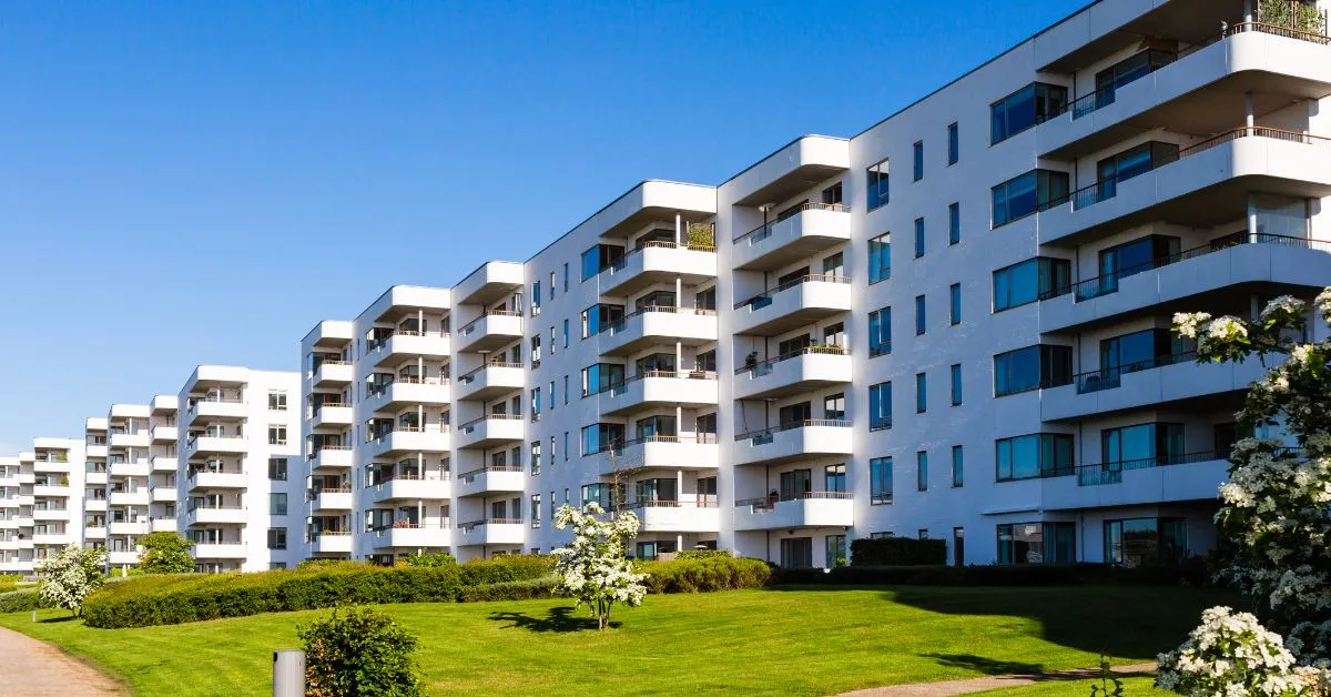 Fachada de condomínio residencial com jardins bem cuidados e sacadas modernas