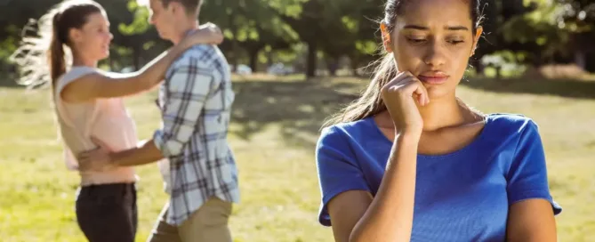 Mulher pensativa ao observar casal, ilustrando dilemas da união estável com pessoa casada