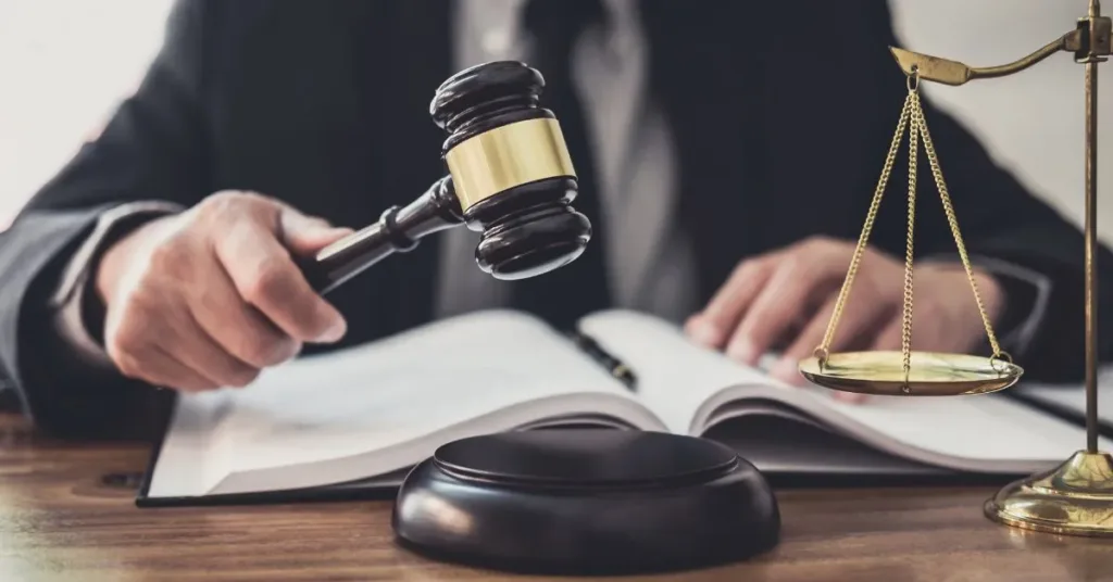 Juiz segura martelo com livro aberto e balança da justiça sobre a mesa – conceito de decisão judicial sobre pensão alimentícia.