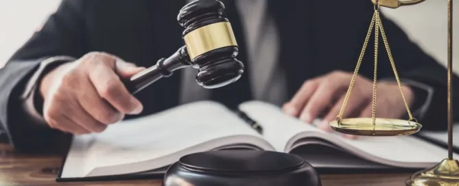 Juiz segura martelo com livro aberto e balança da justiça sobre a mesa – conceito de decisão judicial sobre pensão alimentícia.