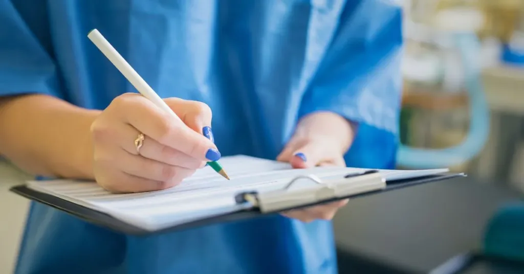Profissional da saúde fazendo anotações em prontuário médico durante atendimento clínico