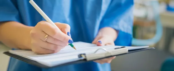 Profissional da saúde fazendo anotações em prontuário médico durante atendimento clínico