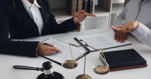 Advogada orientando cliente sobre planejamento sucessório com documentos e balança da justiça sobre a mesa