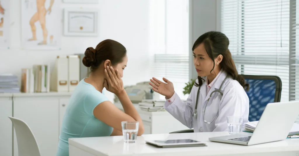 Paciente preocupada durante consulta médica ao ser informada sobre limitação de sessões pelo plano de saúde