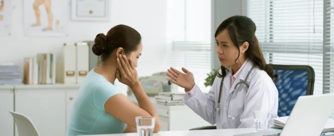 Paciente preocupada durante consulta médica ao ser informada sobre limitação de sessões pelo plano de saúde