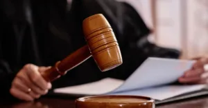 Juiz segurando documento em tribunal durante processo de partilha de bens com herdeiros menores