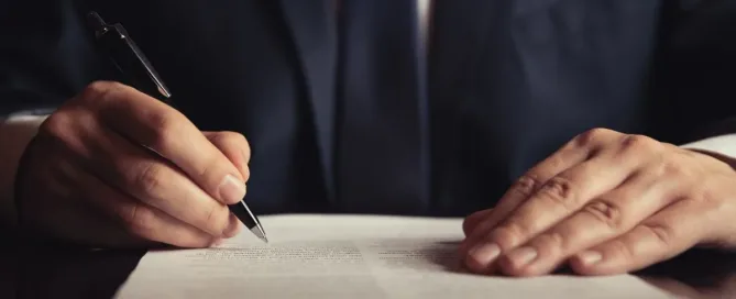 Homem assinando contrato de compra e venda com cláusula de sinal (arras)