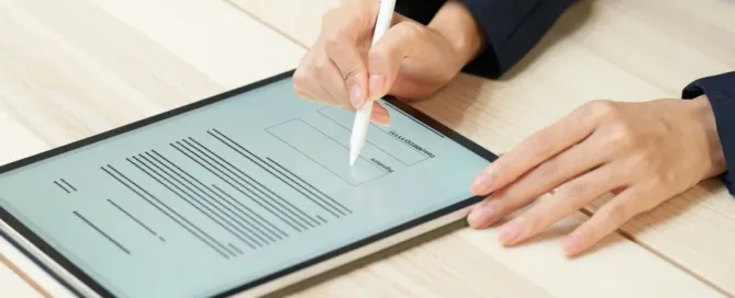 Pessoa assinando documento digital em tablet, representando validade jurídica da assinatura eletrônica.
