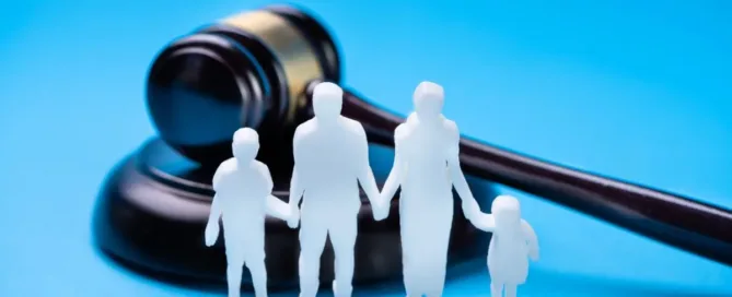 Família representada por figuras em frente a um martelo de juiz, simbolizando decisão judicial sobre guarda compartilhada
