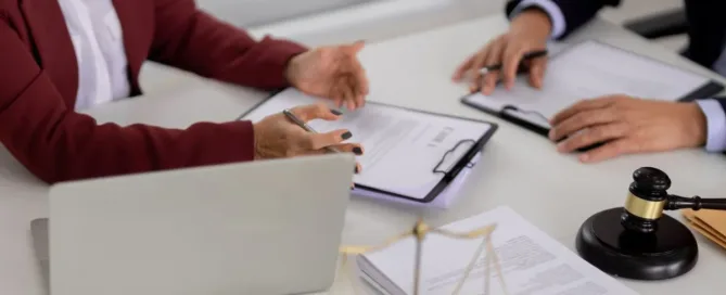 Reunião entre advogados com documentos de inventário e símbolo da justiça sobre a mesa