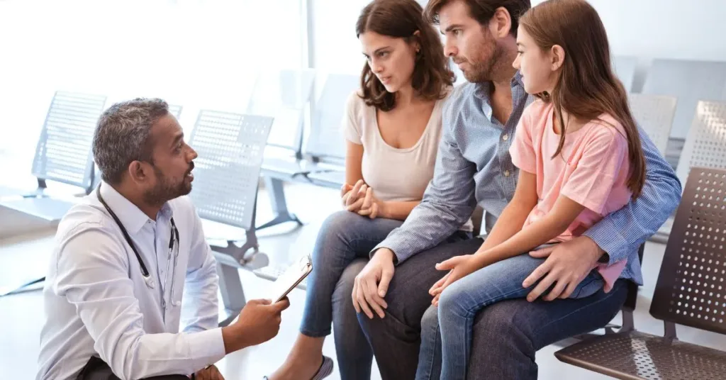 Pais separados conversando com médico sobre decisões médicas do filho em ambiente hospitalar.