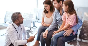 Pais separados conversando com médico sobre decisões médicas do filho em ambiente hospitalar.