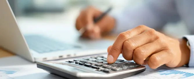 mão usando calculadora para planejar como reduzir impostos na transmissão de herança