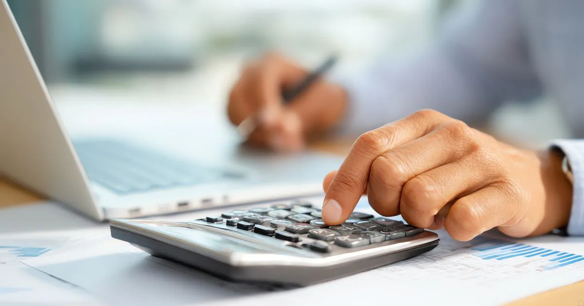 mão usando calculadora para planejar como reduzir impostos na transmissão de herança