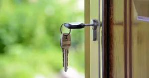 Chave deixada na fechadura de imóvel, simbolizando abandono do imóvel pelo inquilino e a necessidade de medidas legais pelo proprietário.