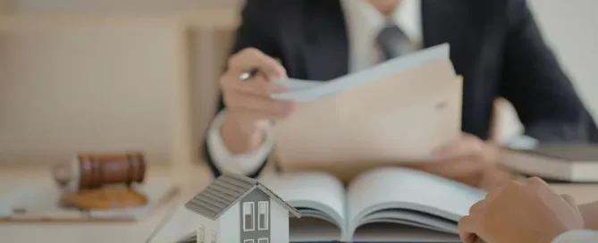 Análise jurídica de benfeitorias em imóvel alugado, com contrato de locação e maquete de casa sobre a mesa.