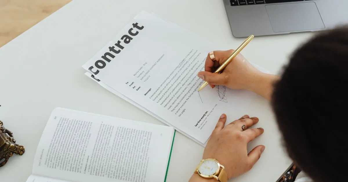 Pessoa assinando contrato em papel, analisando cláusulas antes da assinatura, em situação que pode indicar contrato assinado sob engano.