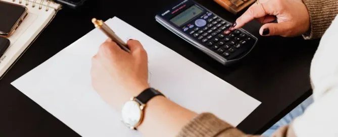 análise de dívidas do falecido com calculadora e documentos durante inventário