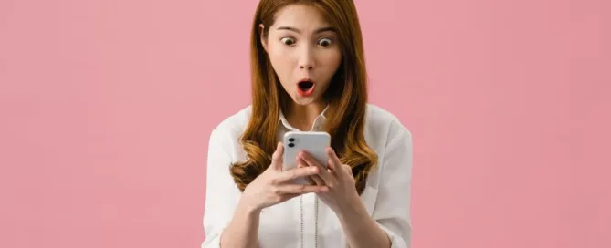 Pessoa olhando o celular com surpresa ao identificar um possível golpe do Pix em transação bancária.