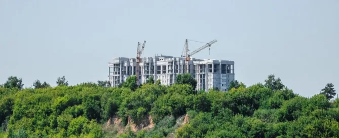 Construção de edifício em área de preservação permanente, ilustrando imóvel localizado em APP e os limites legais para regularização ambiental.