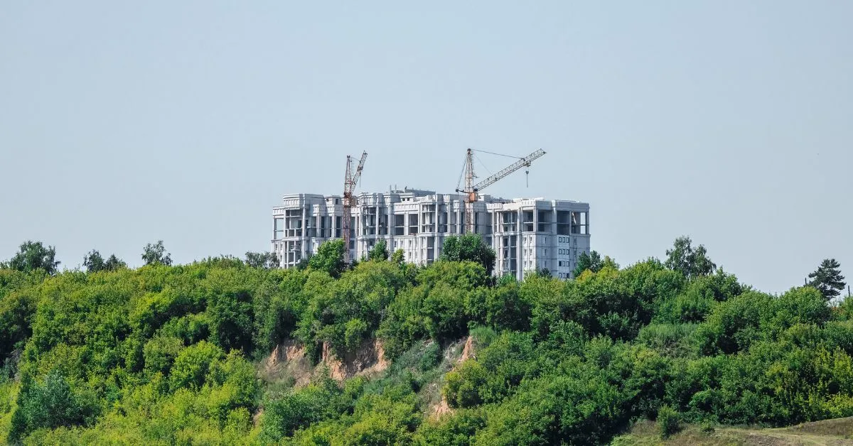 Construção de edifício em área de preservação permanente, ilustrando imóvel localizado em APP e os limites legais para regularização ambiental.