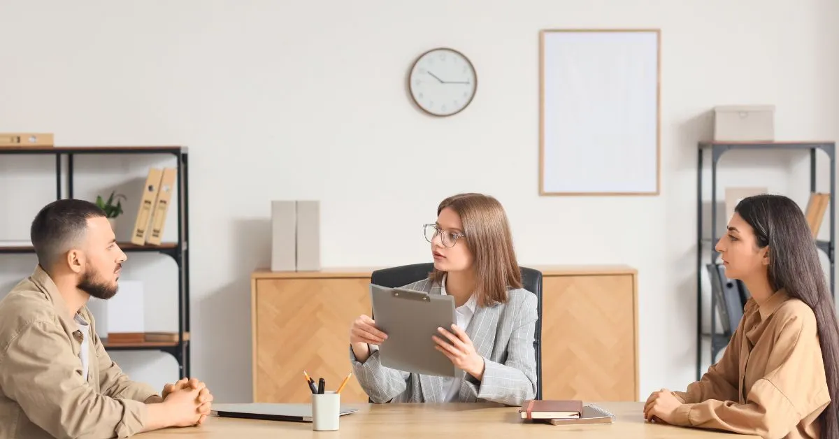Mediação familiar em casos de conflito entre partes Mediação familiar com casal em conflito sendo orientado por mediadora em ambiente profissional e neutro