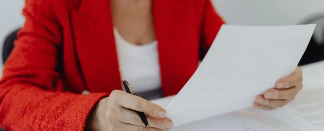 Pessoa analisando e assinando documento de renúncia de herança, representando decisão consciente no direito de sucessões.