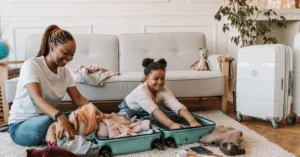 Mãe organizando mala de viagem com filha menor em casa antes de viagem nacional após separação dos pais