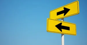 Herança e pensão por morte representadas por placas de direção opostas, ilustrando direitos diferentes após o falecimento