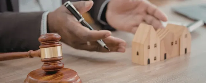 Venda de imóvel antes do inventário representada por martelo judicial e casas sobre mesa