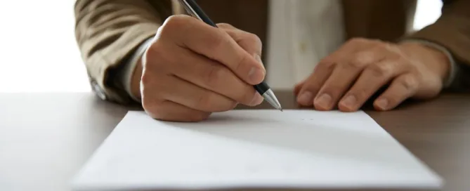 Pessoa assinando documento imobiliário para ilustrar a diferença entre escritura e registro do imóvel