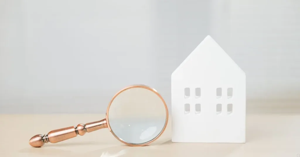 Casa em miniatura com lupa representando análise de contrato de compra e venda de imóvel que pode ser anulado